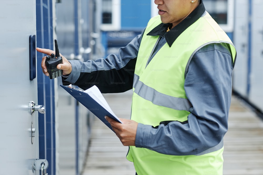 Toma recortada del trabajador ingresando el código clave en la unidad de almacenamiento y sosteniendo el portapapeles