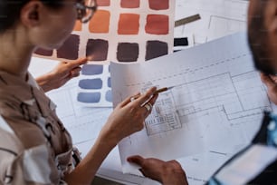 인테리어 디자인 프로젝트를 위한 평면도와 색상 견본에 대해 논의하는 두 건축가의 클로즈업