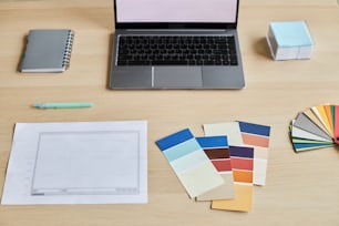 Top view of designers workplace with palette swatches and laptop, copy space