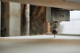 Foto macro da máquina de gravação CNC cortando madeira em oficina de produção automatizada com flocos de serragem no ar, espaço de cópia
