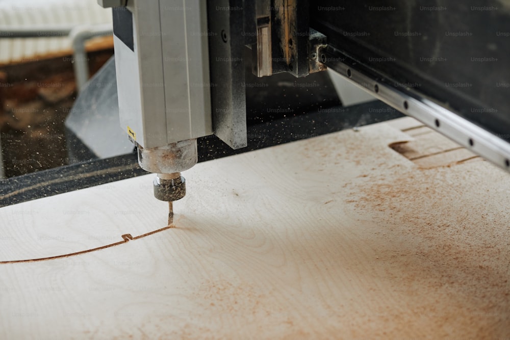 Primo piano della macchina per incisione CNC che taglia il legno in officina di produzione automatizzata con scaglie di segatura in aria, spazio di copia