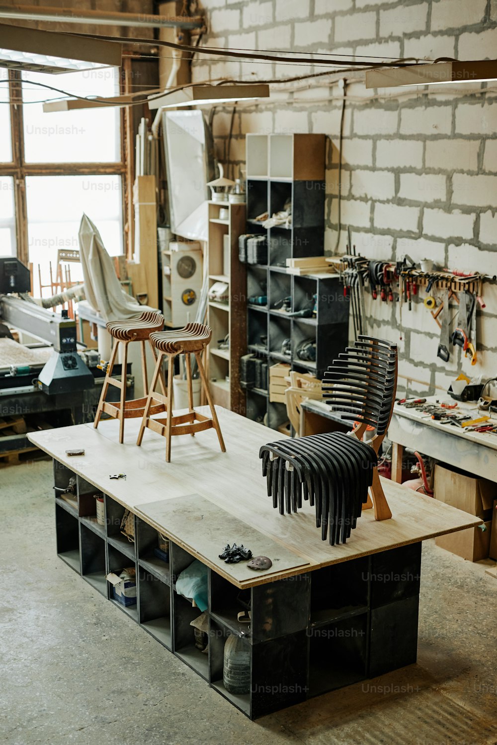 Vertical background image of artisan carpentry workshop in warm tones with focus on handcrafted designer furniture