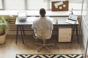 オフィスの窓際で作業しながら文書を分析する黒人起業家の最小上面図、コピー用スペース
