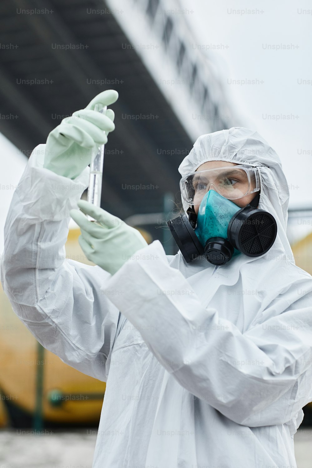 屋外でサンプルを収集する危険物のスーツを着た女性科学者のウエストアップポートレート、有毒廃棄物と汚染のコンセプト