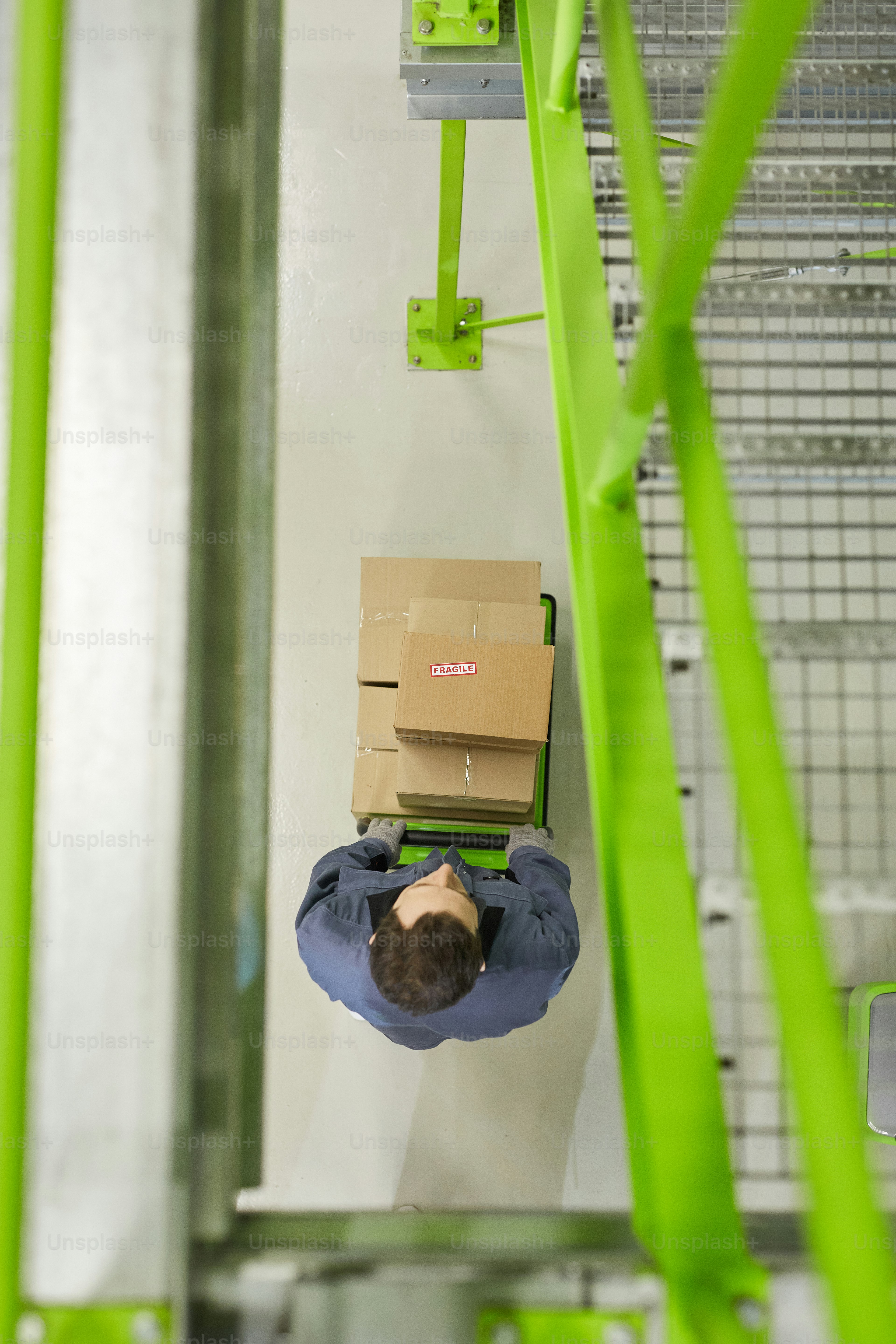 Vista de alto ángulo de la persona que transporta cajas con carrito y las envía