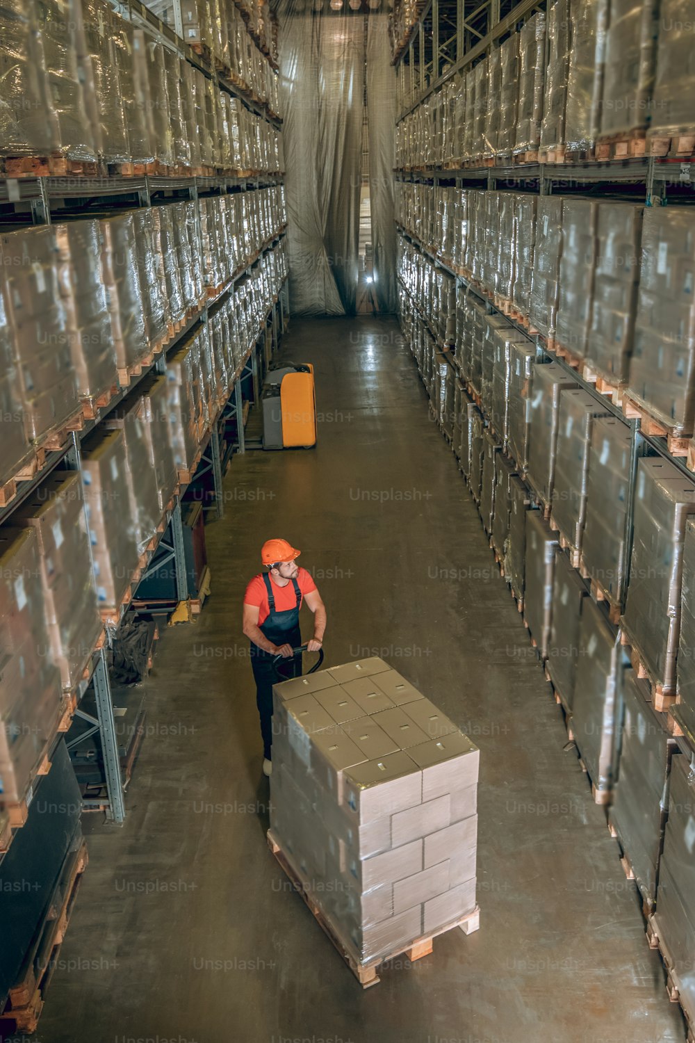 Warehouse. View of a person in a storage compartment with lots of containers on the shelves