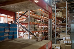 Intérieur d’un entrepôt moderne avec de nombreuses boîtes en carton disposées sur les étagères en acier inoxydable