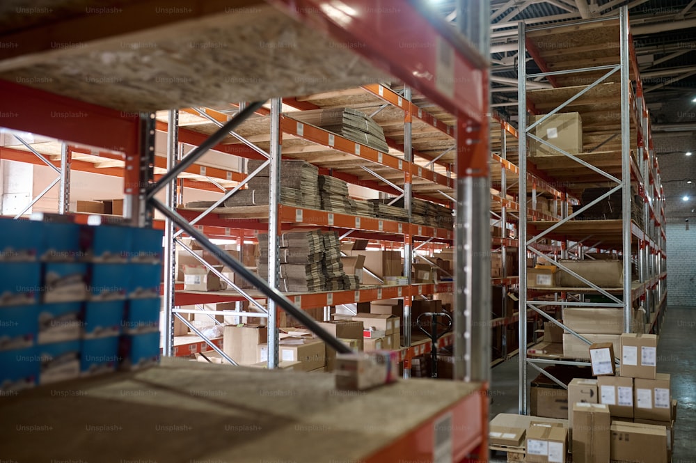 ステンレス製のラックに配置された多数の段ボール箱を備えた近代的な倉庫の内部