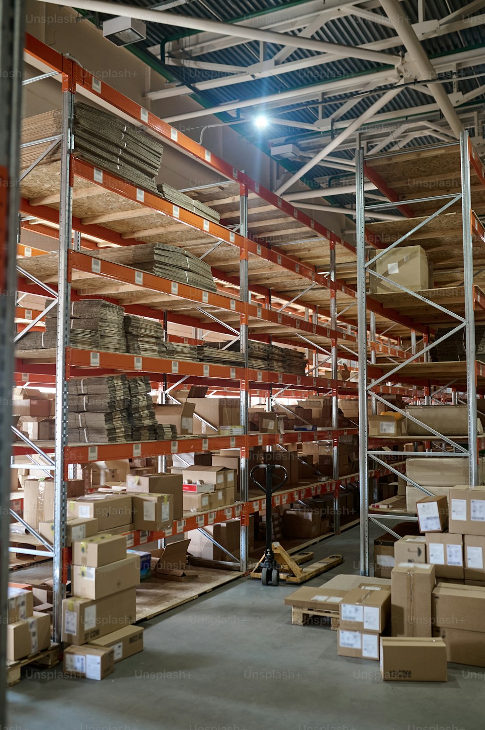 Interior of a modern storage facility with numerous shipping cartons arranged on the stainless steel racks