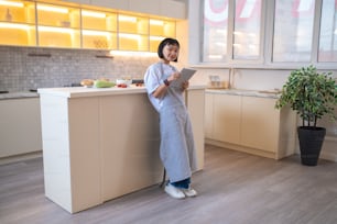 Looking for recipe. A girl in the kitchen reading a cookery blog online