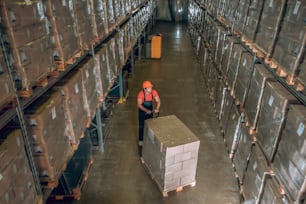 Work in warehouse. View of a person in megastore with lots of containers on the shelves