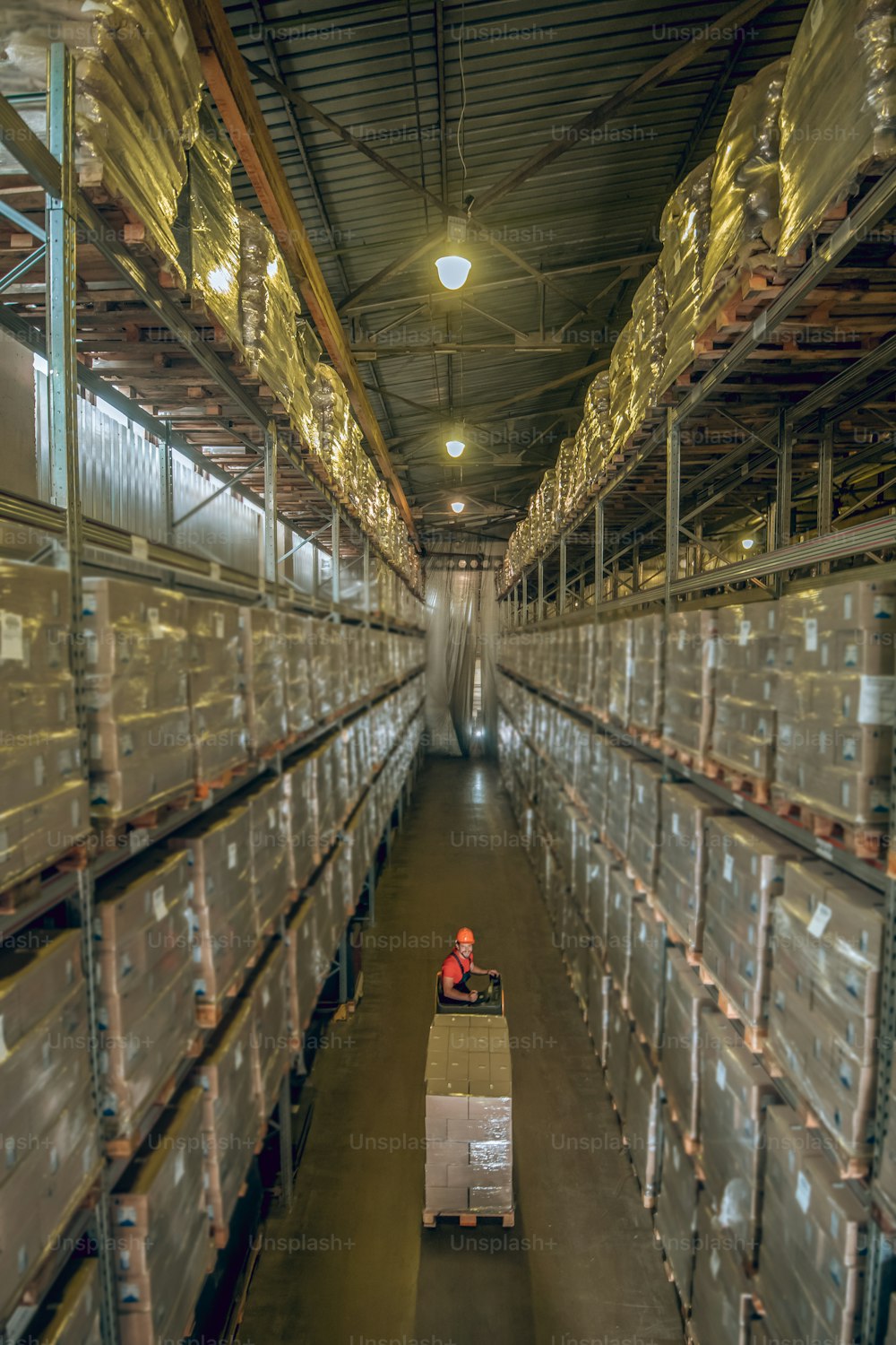 Storage. Warehouse worker going among the shelves in a warehouse