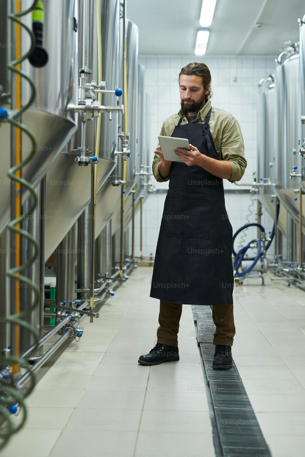 Beer brewery owner controlling production process via application on digital tablet