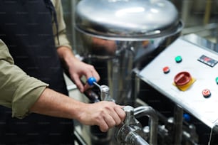 Mãos do trabalhador operando equipamentos de cervejaria para definir a pressão necessária