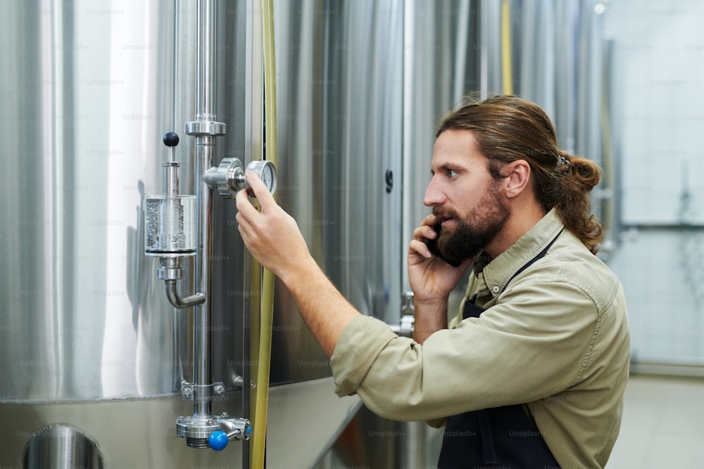 Small brewery owner calling to technician when checking barometer