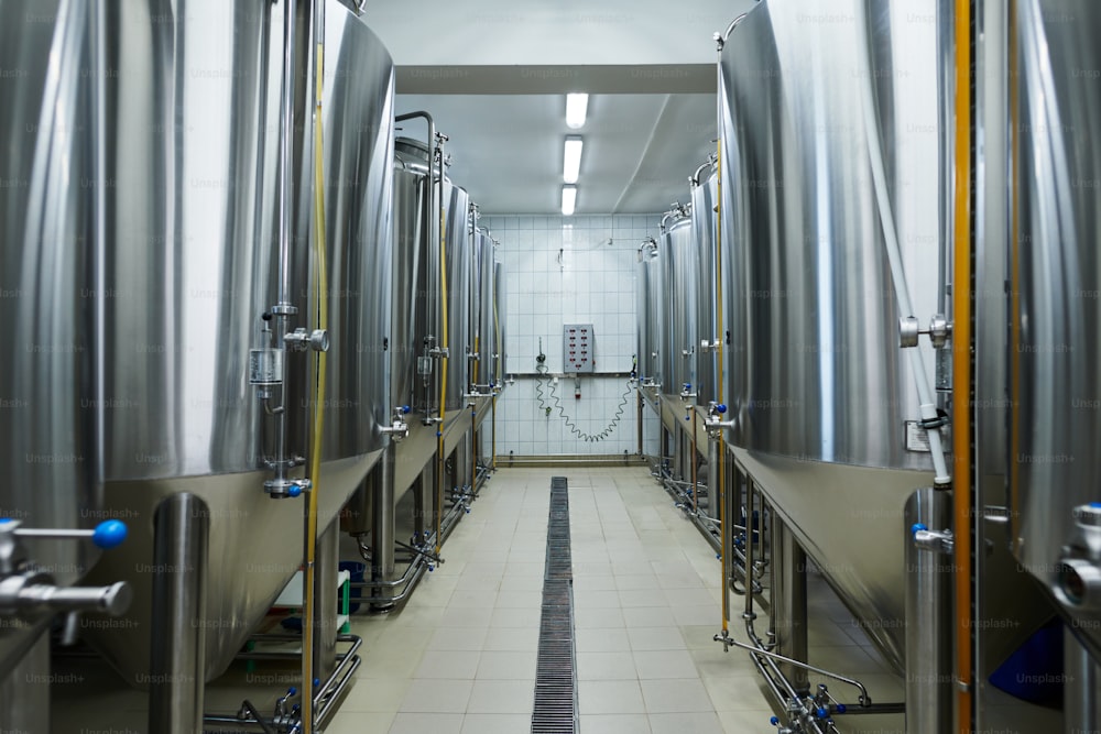 Microbrewery interior with many still tanks full of fermintating beer