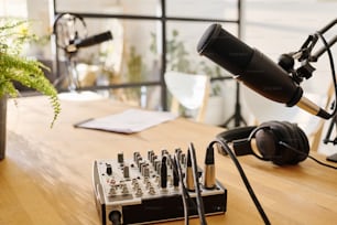 Group of equipment and supplies necessary for podcasting occupation put on desk which is workplace of modern host