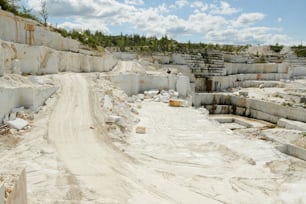 Territorio di grande cava di marmo circondato da spessi muri in pietra bianca con strada per camion e macchine edili