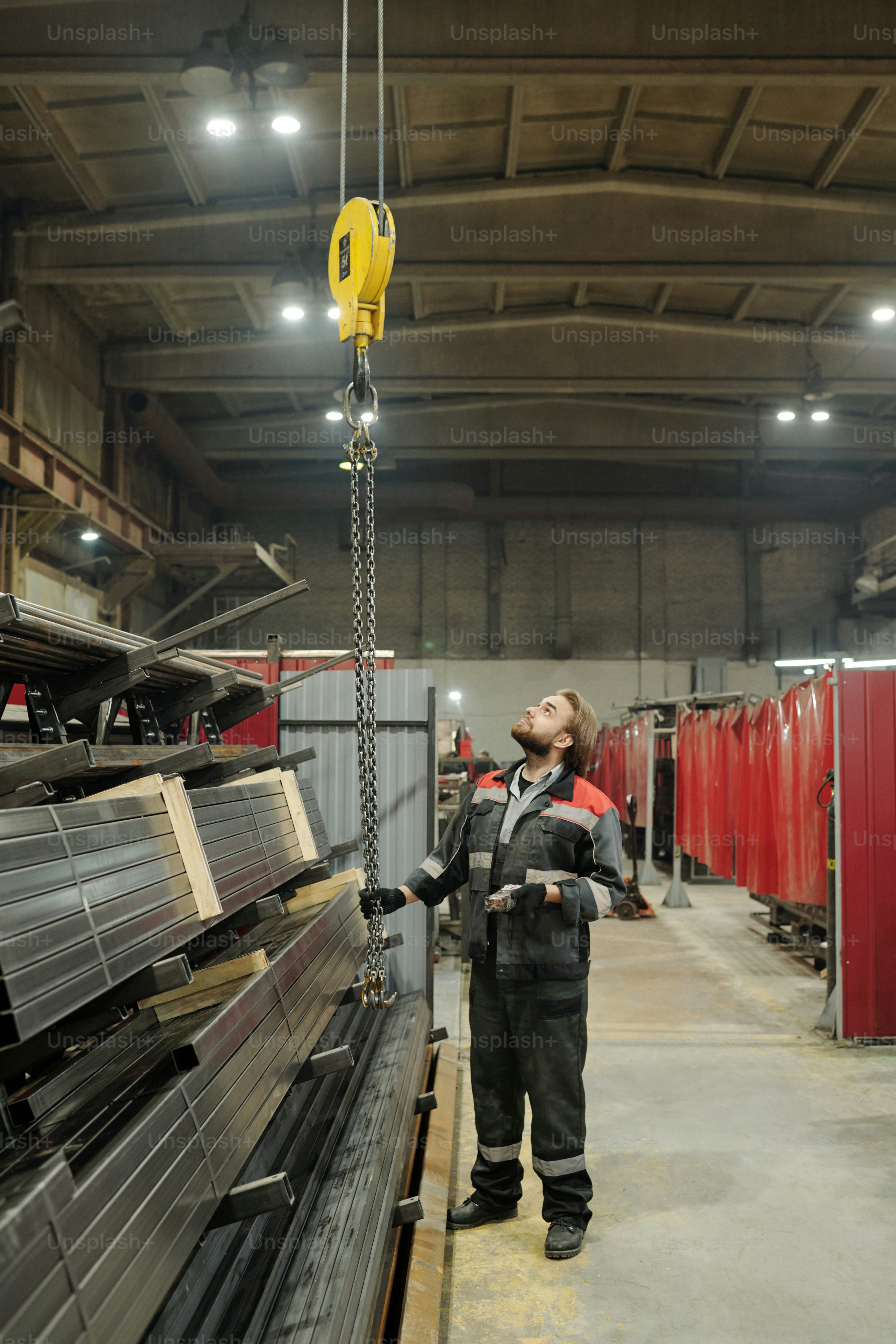 Jeune ingénieur professionnel ou réparateur vérifiant le réglage de la machine industrielle lors d’un contrôle technique en atelier