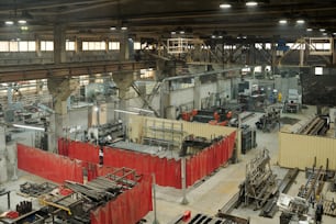 Part of interior of spacious industrial factory with several plants or workshops equipped with huga machines and metallic details