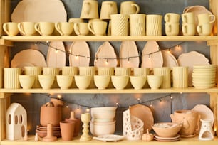 Große Ausstellung mit einer Vielzahl von handgefertigten Steingut- und Tonartikeln wie Tassen, Schalen, Töpfen und Tellern zum Verkauf in einem kleinen Kunsthandwerksladen