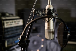 Horizontale No-People-Aufnahme eines Kondensatormikrofons mit Disc-Pop-Filter im modernen Tonstudio