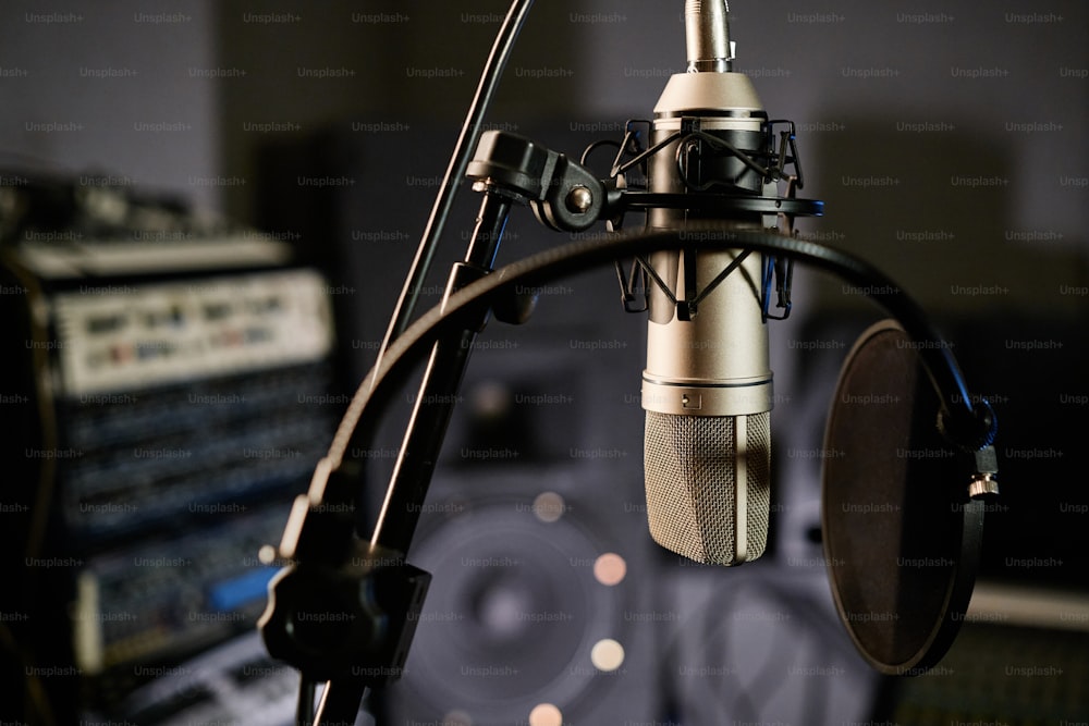 Horizontal no people shot of condenser microphone with disc pop filter in modern recording studio