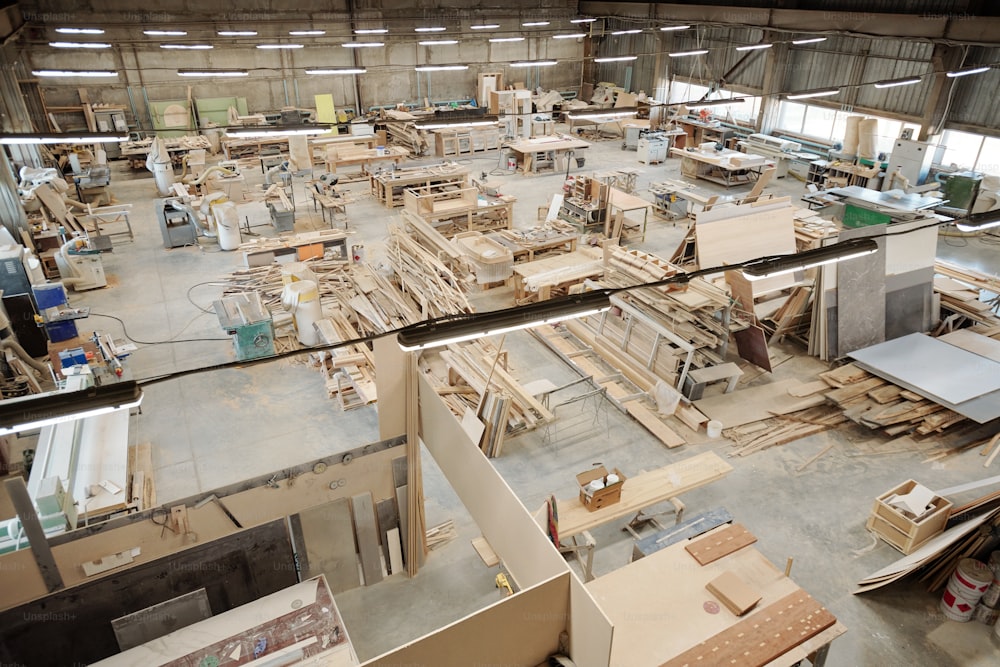Interno del grande laboratorio di fabbrica di mobili contemporanei con postazioni di lavoro costituite da banchi da lavoro con forniture di lavoro
