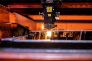 Heavy part of huge indistrial welding or laser cutting machine during working process inside workshop