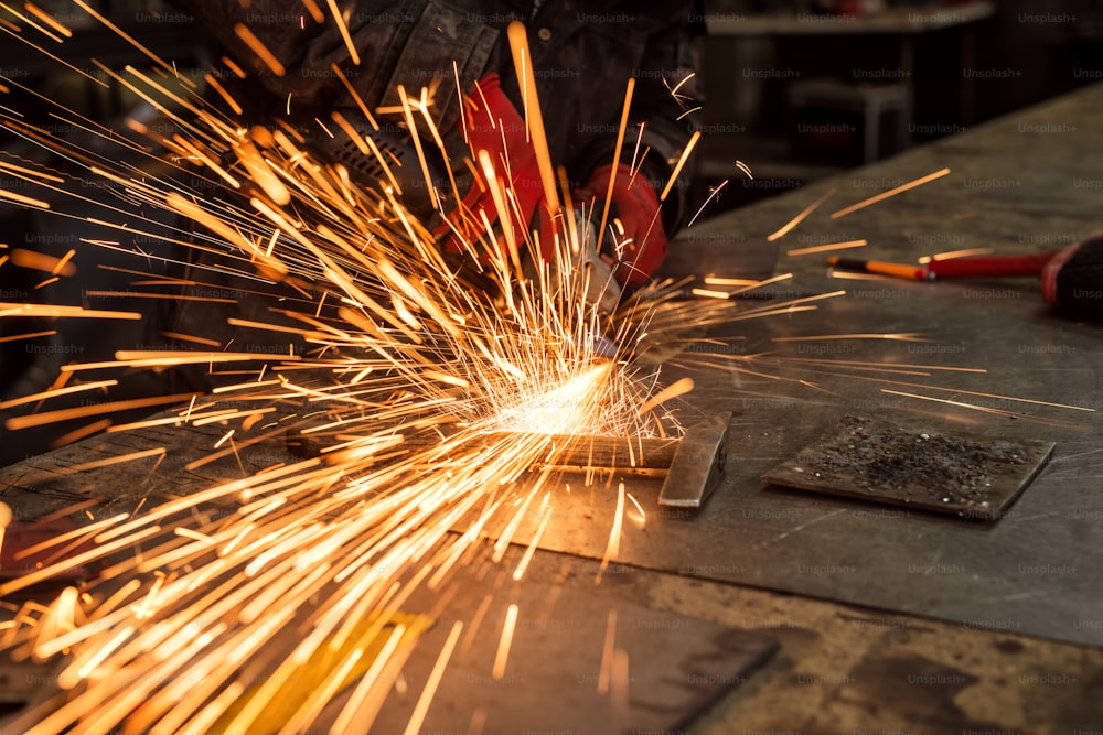 Craftsman sawing metal, sparkles around workshop.