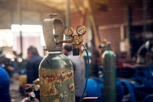 Vista de foco de perto do equipamento de soldagem. Tanque de cilindro de gás acetileno com manômetros reguladores de calibre na oficina de tecidos industriais.