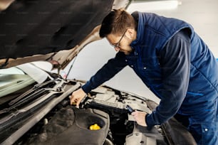 Ein Automechaniker repariert den Automotor in der Garage.