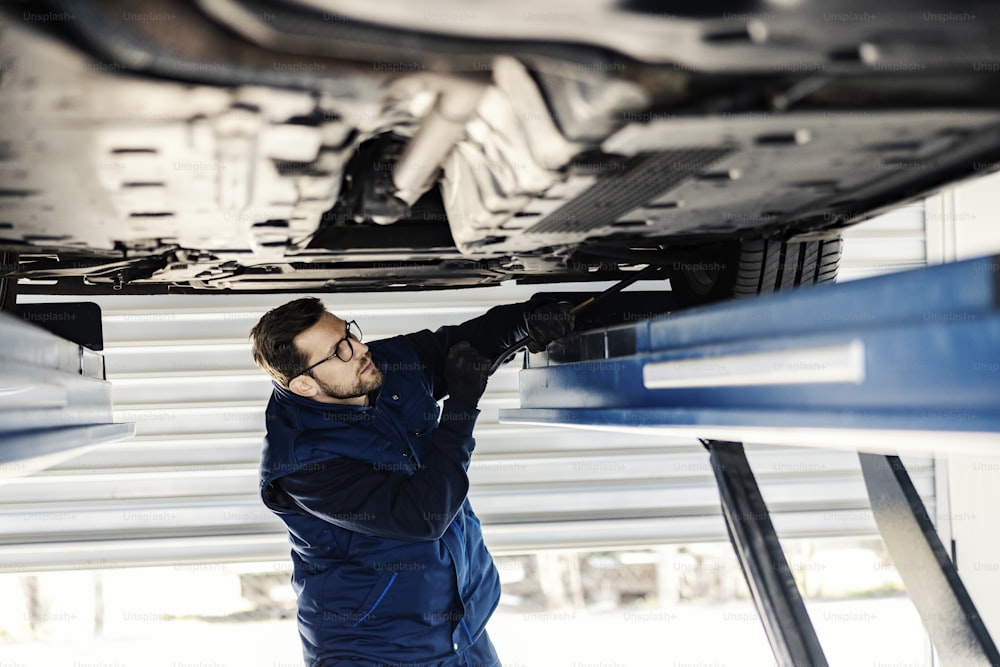 An auto mechanic fixing tire at mechanic's shop.