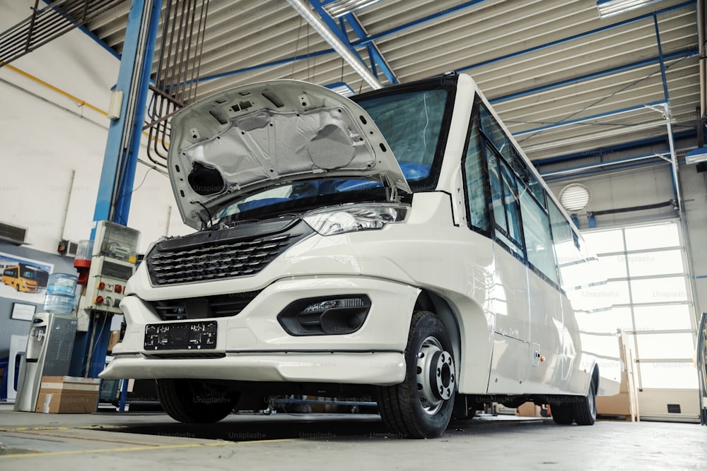 A broken mini bus at auto mechanic's workshop.