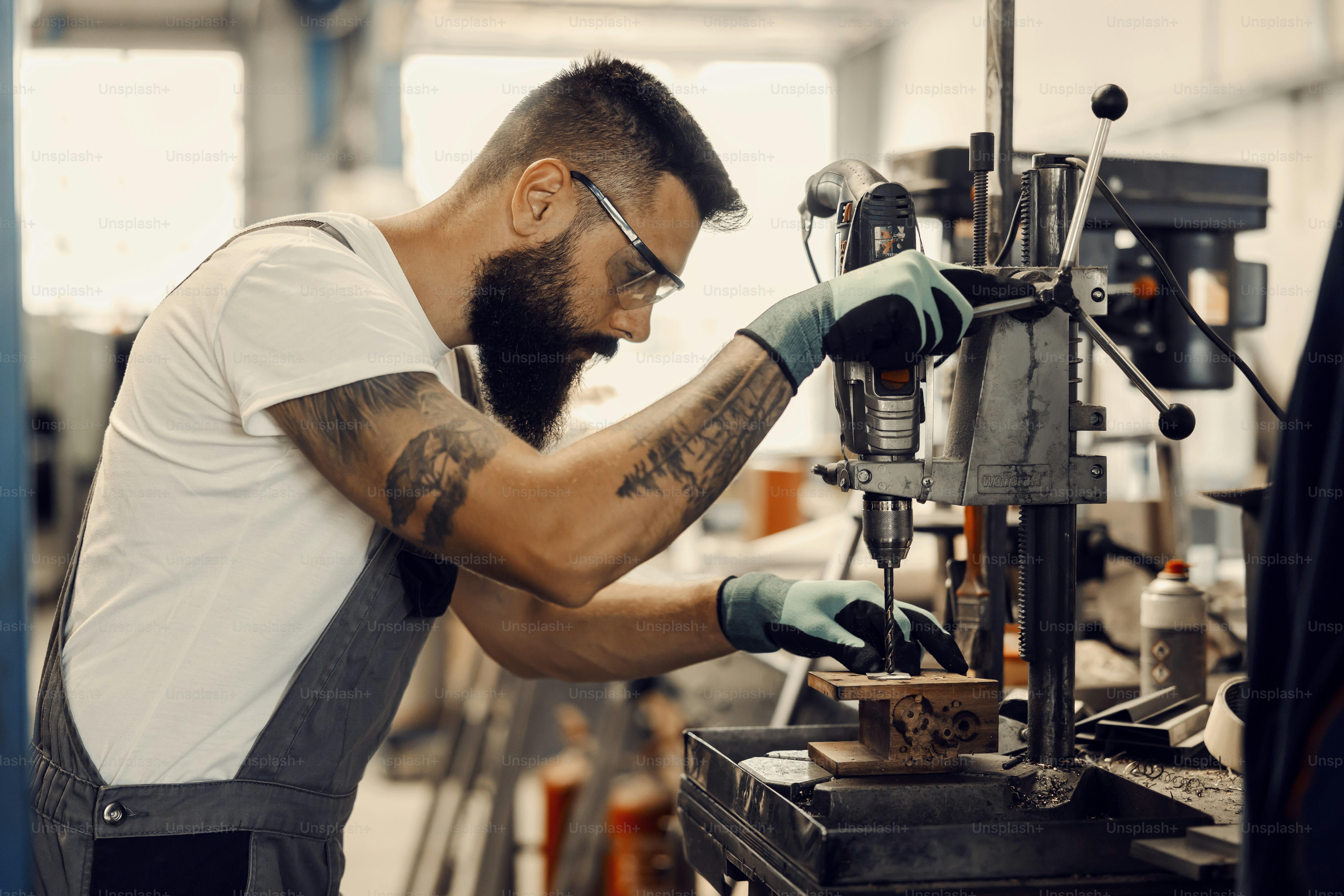 Un trabajador usando taladro en el taller.