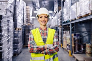 A successful warehouse worker standing with arms crossed.