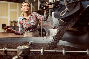 A factory worker roasting coffee in facility.