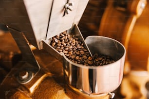 Close up de grãos de café na máquina de café de moagem.