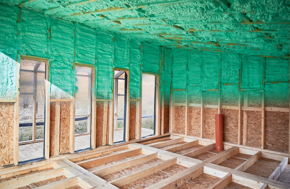 スカンジナビア風の納屋の木造フレームハウスの断熱室の前後の写真コラージュ。ポリウレタンフォームでスプレーされた壁の比較。建設と断熱のコンセプト。