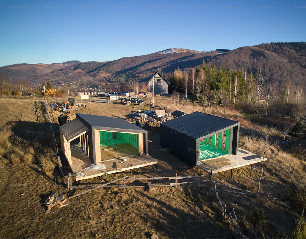 Vista aerea di due case con struttura in legno nei fienili in stile scandinavo isolate con schiuma di poliuretano. Concetto di costruzione e isolamento.