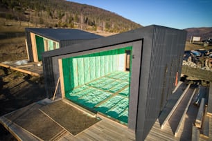 Vista con drones de dos casas de madera en los graneros de estilo escandinavo aisladas térmicamente por espuma de poliuretano. Concepto de construcción y aislamiento.