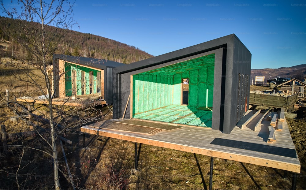 Vista de drone de duas casas de madeira no celeiro de estilo escandinavo com isolamento térmico por espuma de poliuretano. Conceito de construção e isolamento.