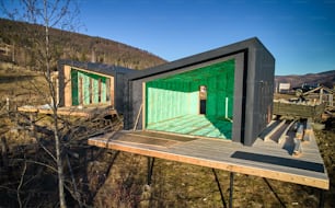 Vue par drone de deux maisons à ossature de bois de style scandinave isolées thermiquement par de la mousse de polyuréthane. Concept de construction et d’isolation.