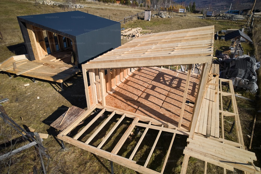 Vue aérienne d’une maison à ossature bois sur pieux en construction dans les montagnes.