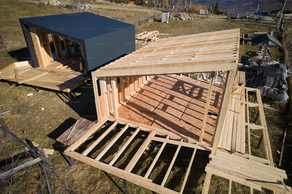Aerial view of wooden frame house on pile foundation under construction in the mountains.