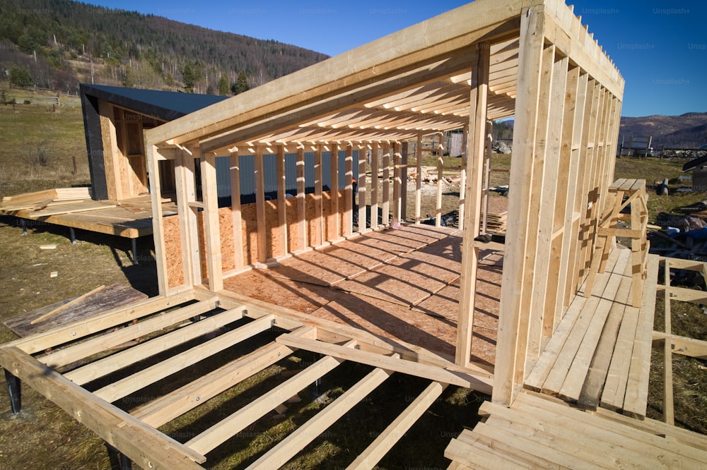 Vista aerea della casa con struttura in legno sulla fondazione su pali in costruzione in montagna.