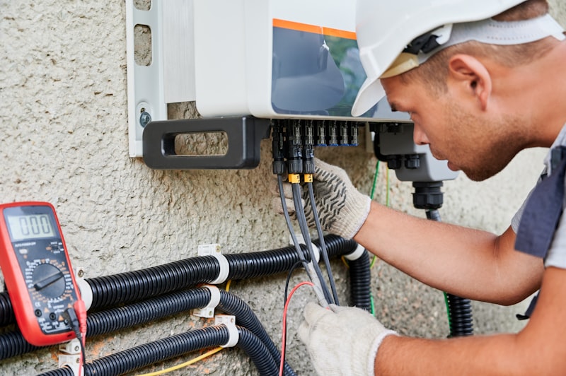 Monteur installeert omvormer bij zonnepanelen