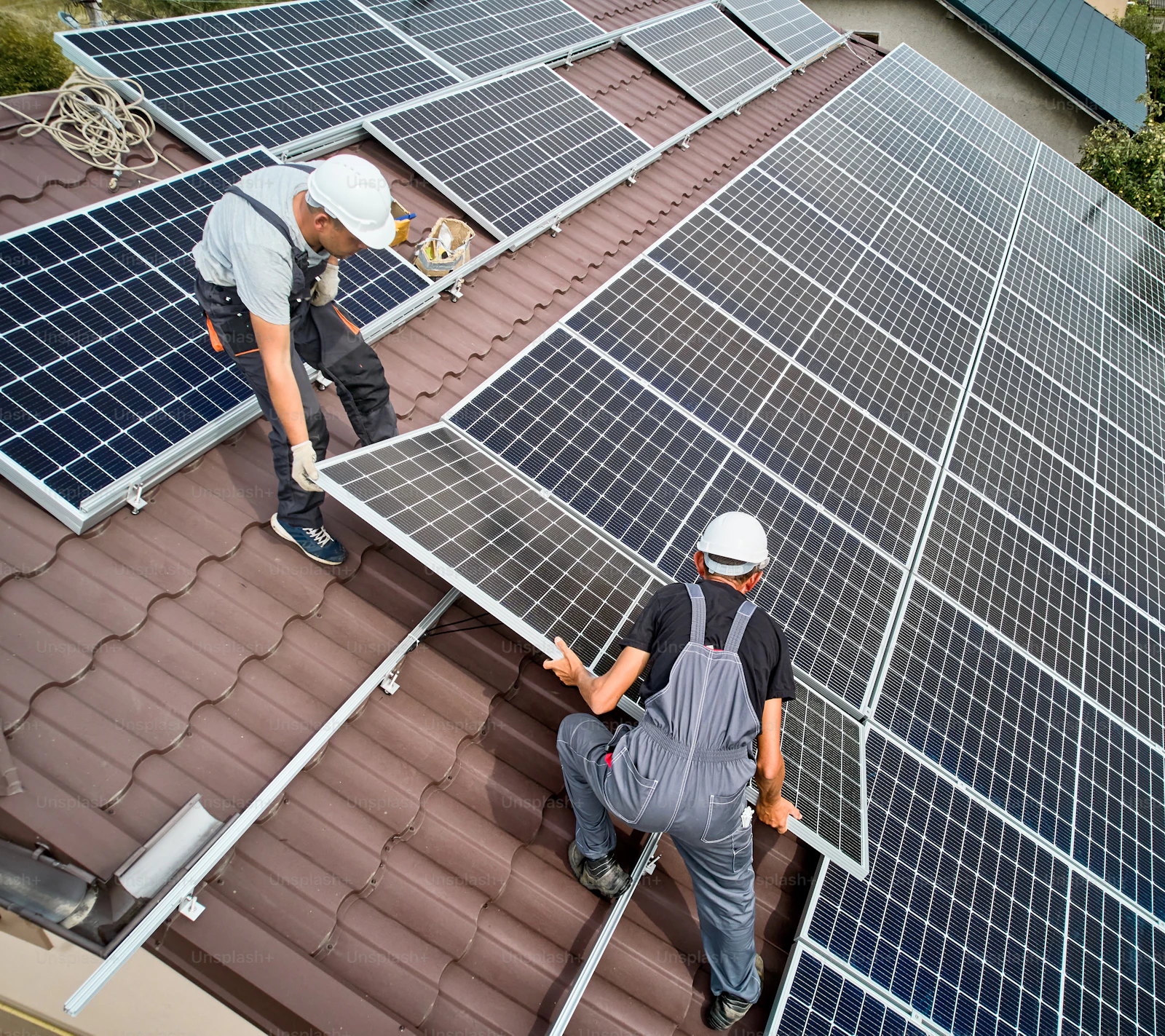 Installers fitting solar panels on a residential roof