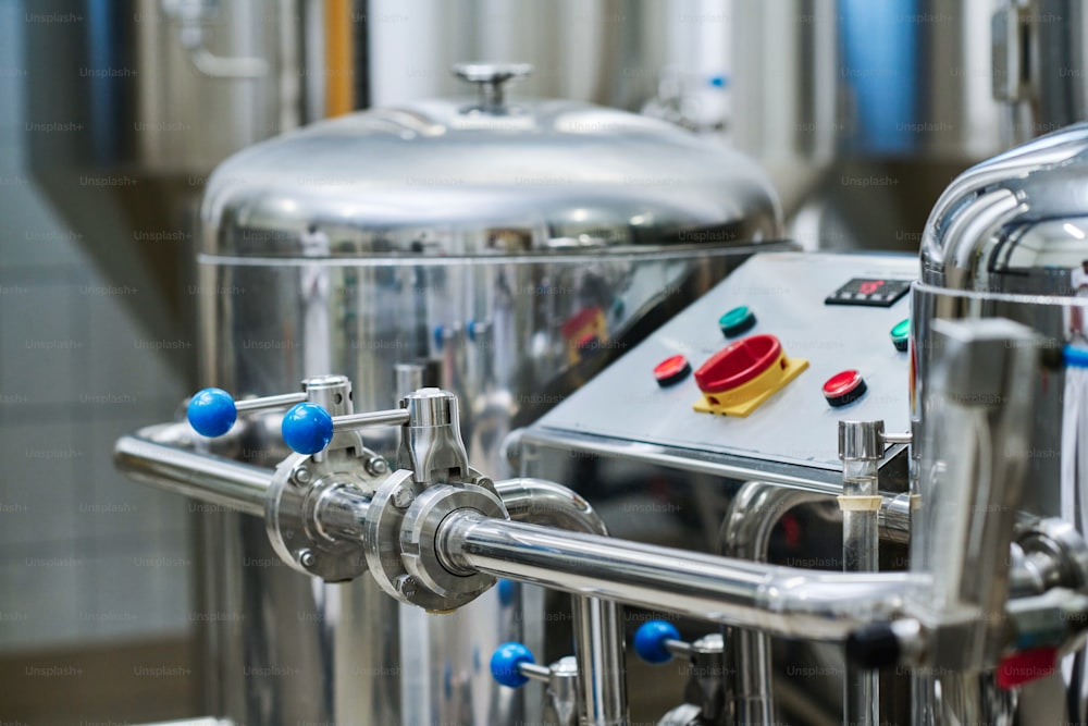 Close-up of stainless steel tanks with control panel for brewing beer in factory