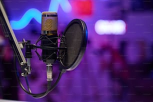 Toma horizontal sin enfoque selectivo del micrófono con filtro de pop de disco en un estudio de grabación moderno